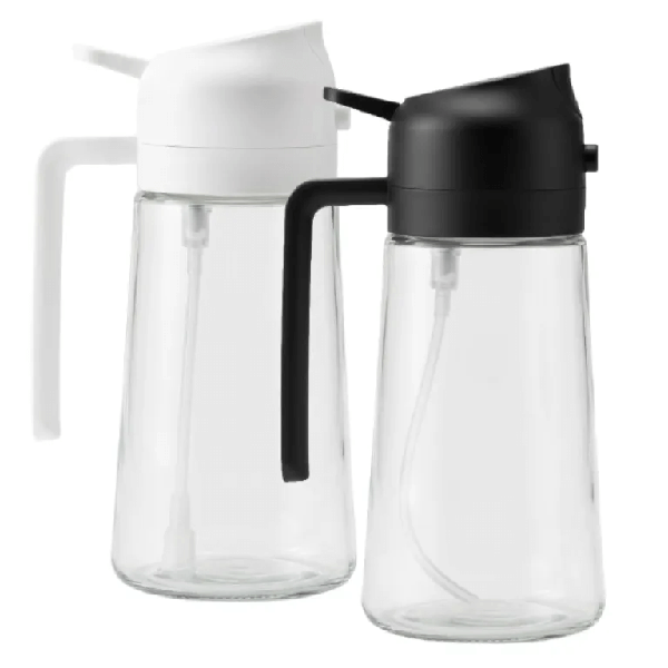 מרסס שמן מזכוכית עם ידית ומנגנון התזה בצבע שחור ולבן בעיצוב דקורטיבי למטבח.